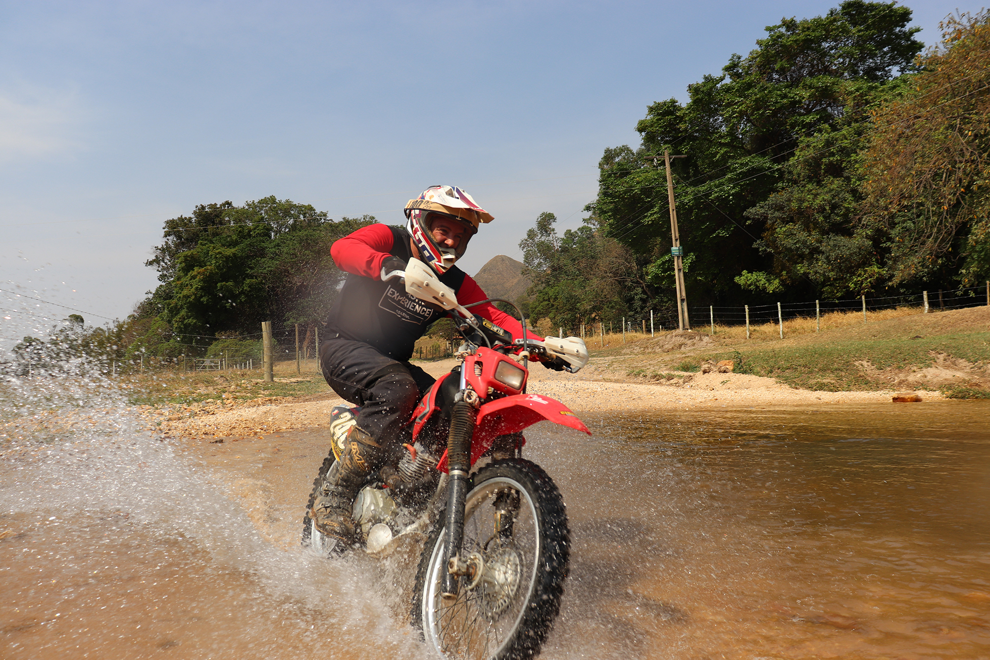 Piloto de moto em travessia de água, fotografia de referência da região